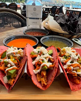 red-shell tacos with dips and tequila behind